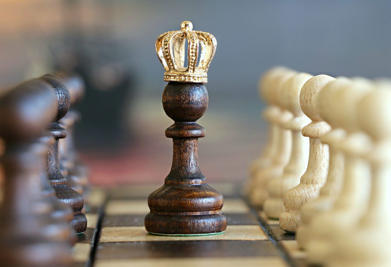 obsessed with the subconscious mind - pawn in the middle of a chessboard with a mini golden crown on its head