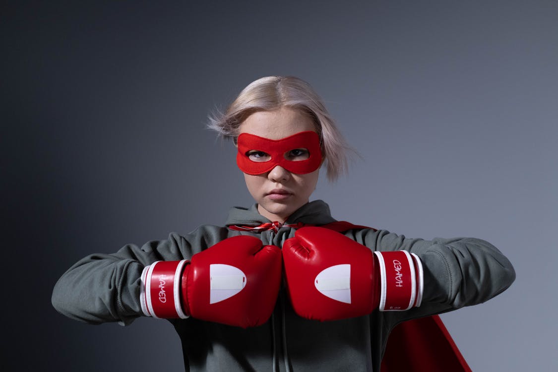 Power up 2022 - blond woman in a red superhero mask with red boxing gloves on fists meeting in front of her